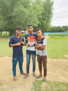 three young men holding trophies in a field with a vivo v11 pro dual camera