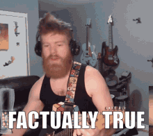 a man with a beard is playing a guitar in front of a sign that says actually true