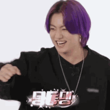 a person with purple hair is wearing a black shirt and a necklace .