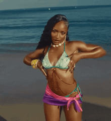 a woman in a bikini dancing on the beach