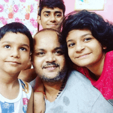 a man and three children pose for a picture and one of the children is wearing a shirt that says ' td '