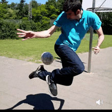 a man in a blue shirt kicks a soccer ball in the air