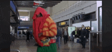 a man in a clown costume is walking through an airport terminal