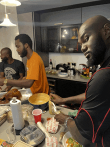 a man wearing a shirt that says ' liberty city ' on it prepares food