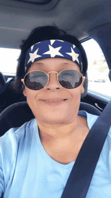 a woman wearing sunglasses and a headband with stars is sitting in a car