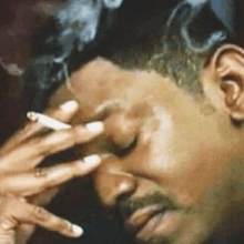 a man is smoking a cigarette with smoke coming out of his eyes .
