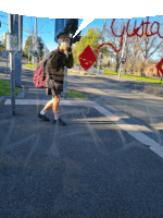 a person walking down a street with the word gusto written on the sidewalk