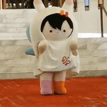 a stuffed animal wearing a white bunny costume is walking down stairs