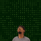 a man with glasses stands in front of a green background with a green cross and the numbers 0 + 14