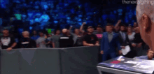 a man is standing in front of a crowd with the words the next big thing written above him