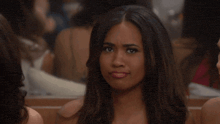 a woman in a red dress looks at the camera with a serious look on her face