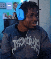 a man wearing headphones and a hoodie that says jesus