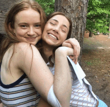 two girls are posing for a picture and one has a bandaged arm