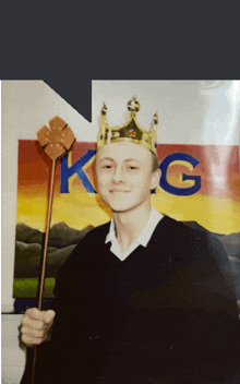 a man wearing a crown and holding a wand in front of a sign that says king