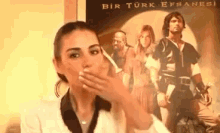 a woman is blowing a kiss in front of a movie poster for bir turk efsanesi