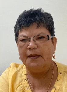 a close up of a woman wearing glasses and a yellow shirt .