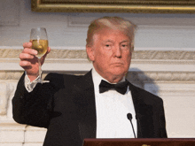 a man in a tuxedo is holding a glass of champagne