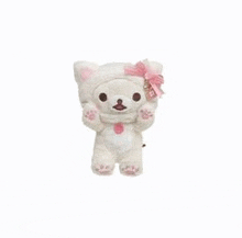 a white teddy bear wearing a cat hat and a pink bow .