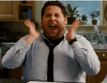 a man wearing a tie and a shirt is screaming in a kitchen .