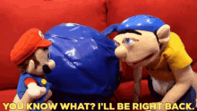 a mario puppet is talking to another mario puppet on a couch