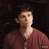 a man wearing a red shirt with the word netflix on the sleeve