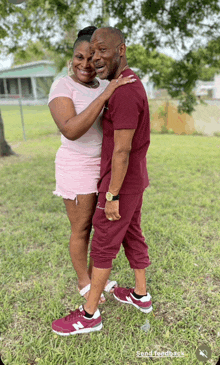 a man and a woman are posing for a picture and the man is wearing maroon shorts