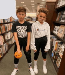 a boy wearing an adidas shirt is holding a basketball