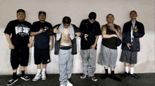 a group of men are standing in front of a wall and one of them is wearing a shirt that says make a choice