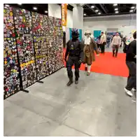 a man in a costume is walking in front of a wall full of pins