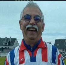 a man with a mustache and glasses is wearing a red white and blue shirt