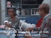 a man and a woman are sitting on a couch with stuffed animals and a caption that says ik hou dat geen dag