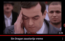 a man in a suit and tie holds his hand to his forehead with the words sin dragan zaustavlja vreme on the bottom