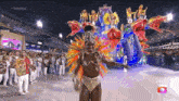 a man in a colorful costume is dancing in front of a crowd with a globeleza logo on the bottom