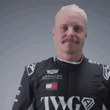 a man with a mustache is wearing a black shirt that says twg on it