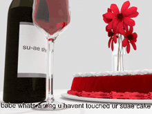 a bottle of su-ae shiraz wine next to a glass and a cake