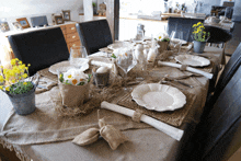 a table set with plates and glasses and flowers