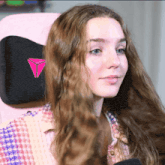 a woman sits in a pink chair with a pink triangle logo on the back