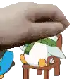 a cartoon duck is sitting on a chair with a person holding it .