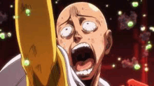 a close up of a bald man with his mouth open and a yellow object in his hand .