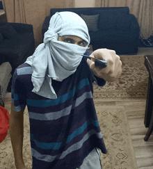 a man with a bandana on his face holds a knife in his hand