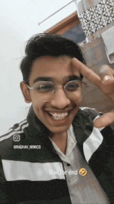 a young man wearing glasses and a black and white jacket with the words wait for end written on the bottom