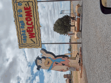 a welcome sign for yabba-dab-a-do with a flintstone statue in front of it