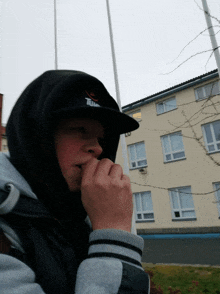 a young man wearing a hooded jacket and a hat that says tim on it