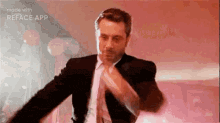 a man in a suit and tie is dancing on a red background .