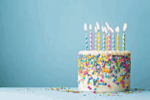 a birthday cake with lots of candles and sprinkles on it