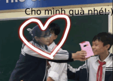 a girl is hugging a boy in front of a blackboard that says cho mình qua nhiều