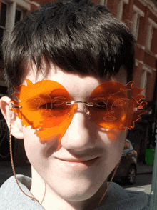 a boy wearing orange sunglasses with a face on them