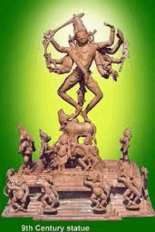 a 9th century statue of a deity with many arms and legs is surrounded by other statues on a green background .