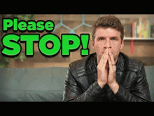 a man in a leather jacket is covering his mouth in front of a green sign that says please stop