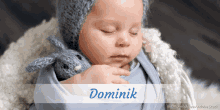 a baby is wrapped in a blue blanket and the name dominik is on the bottom